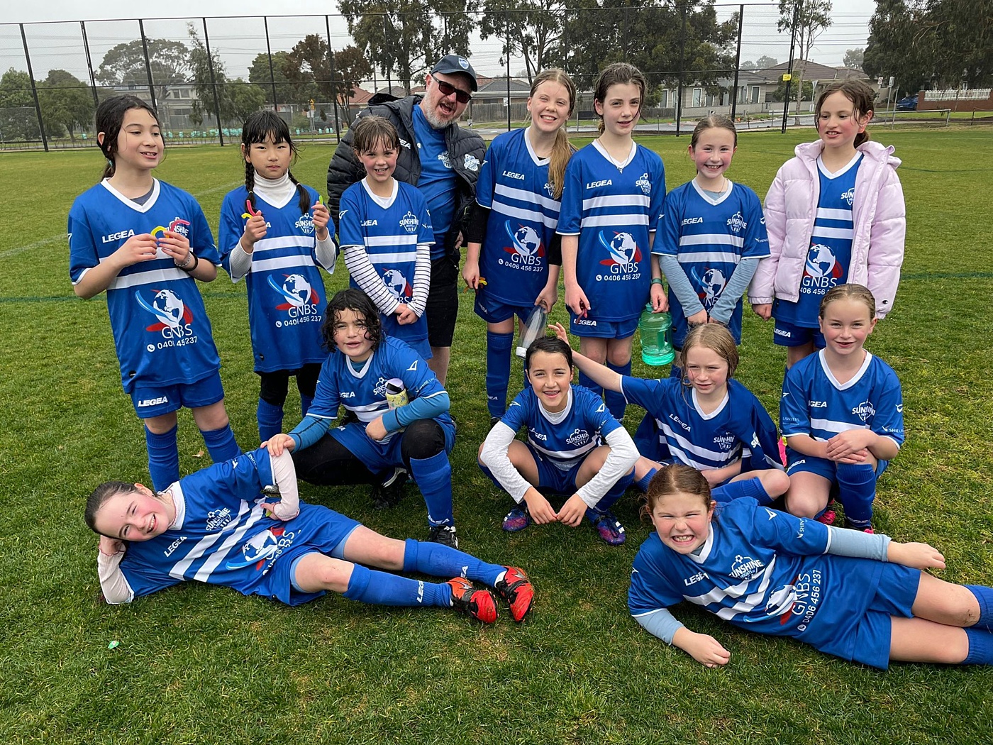 Coach James Waters (centre rear) and daughter Noni (bottom left) with members of the Sunshine Heights JSC junior girls soccer team.